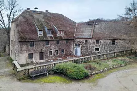 Foto eines alten, teilweise verfallenen Gebäudes mit einer steinernen Fassade