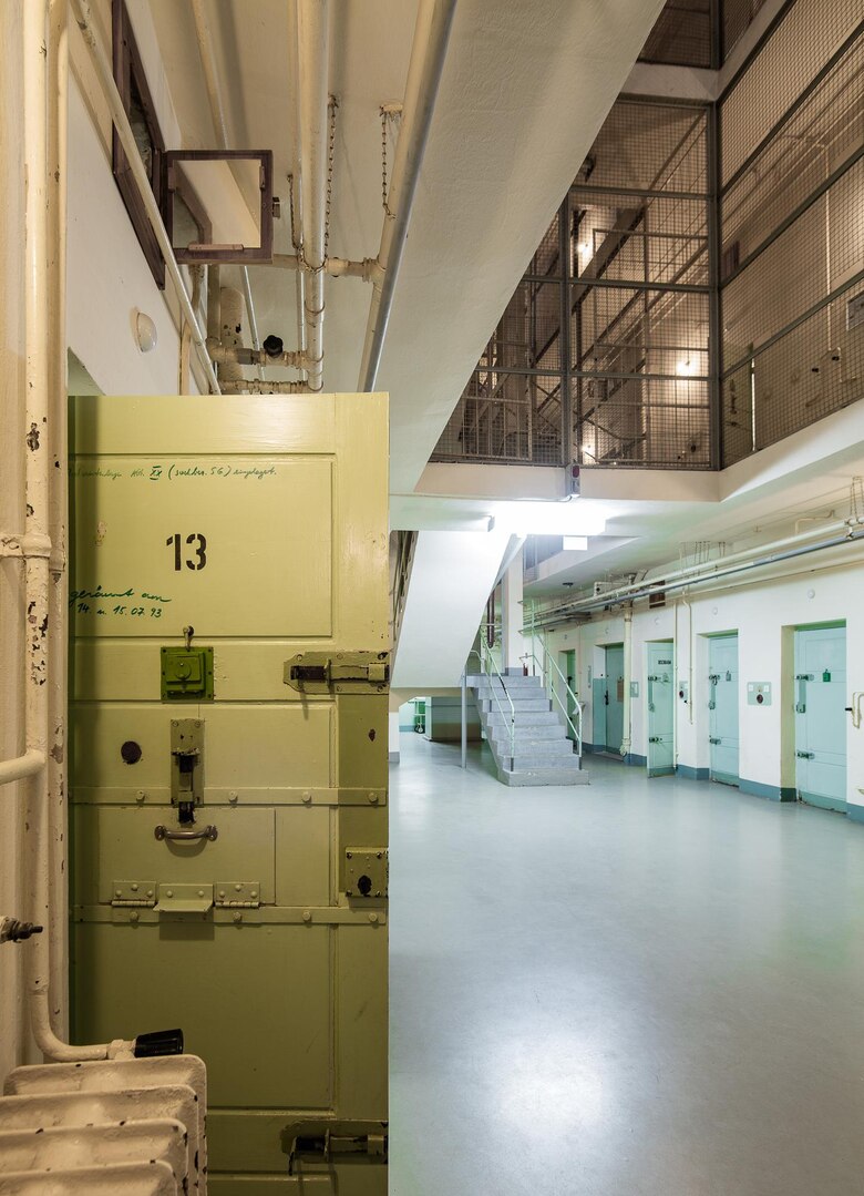 Historischer Gefängnistrakt mit geöffneten Zellentüren