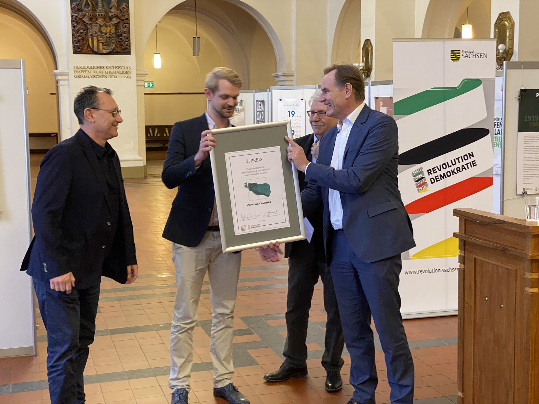 Gezeigt wird wie der Oberbürgermeister der Stadt Leipzig, Burkhard Jung, die Preise an die Preisträger des Wettbewerbs überreicht. 