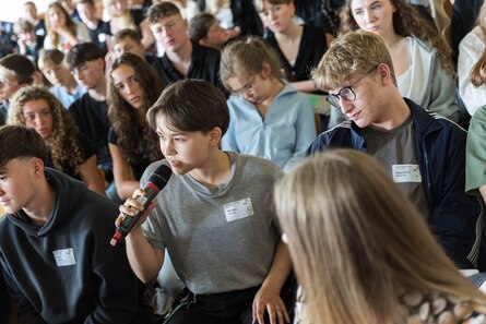Junge Menschen sitzen im Publikum.