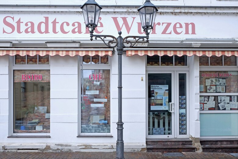 Ein Schaufenster in einer Fußgängerpassage. Vor dem Schaufenster steht eine Laterne.